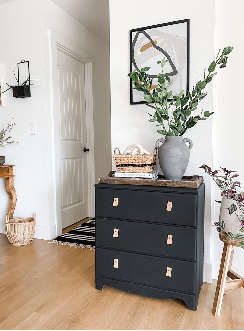 hallway with metal railing, black cabinet dresser with vase and greenery, decor and artwork | Allisa Jacobs Home & Design