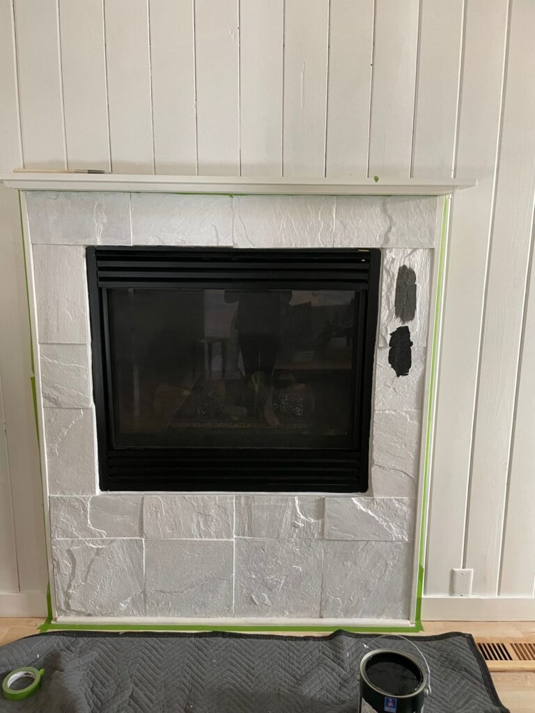 stone fireplace painted with white primer and black paint swatches
