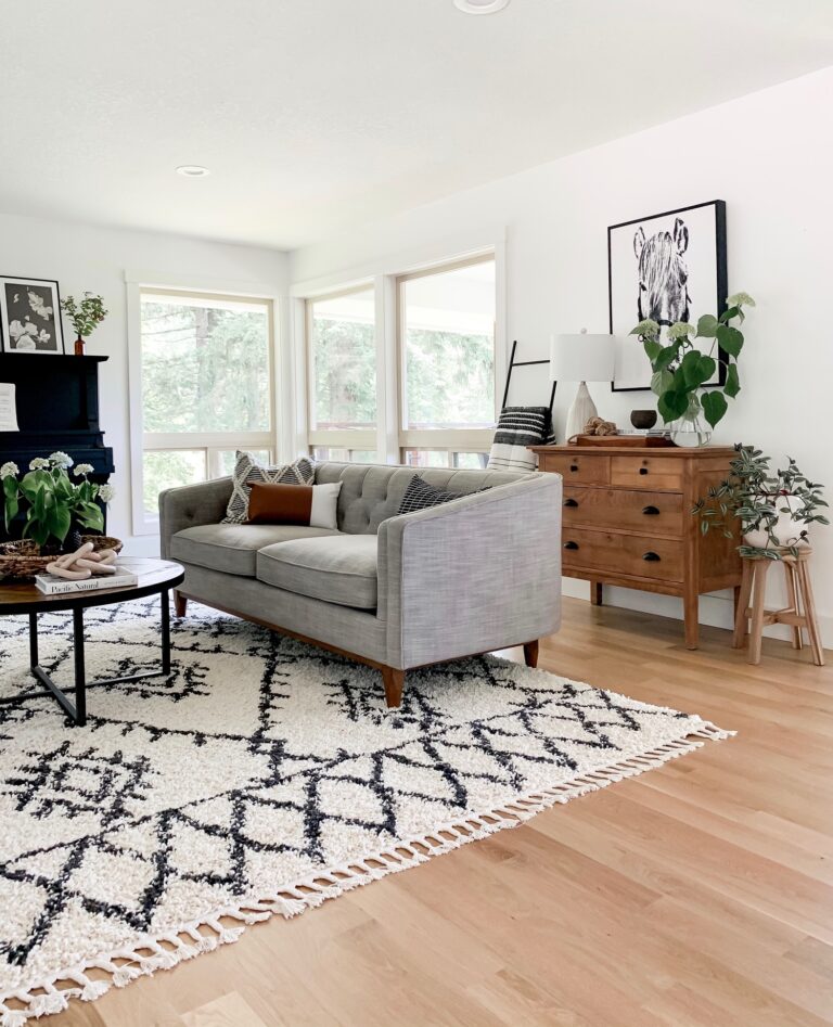 neutral living room with gray couch, boho style rug, and modern decor