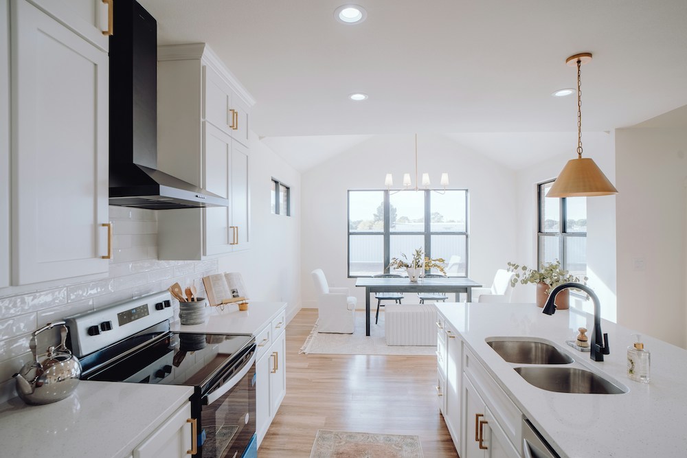 open concept kitchen and dining room with white walls and black accents