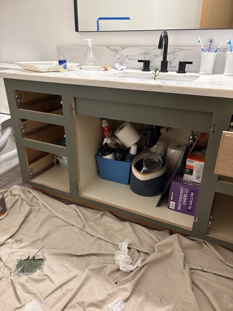 bathroom vanity cabinet being painted green with doors and drawers removed