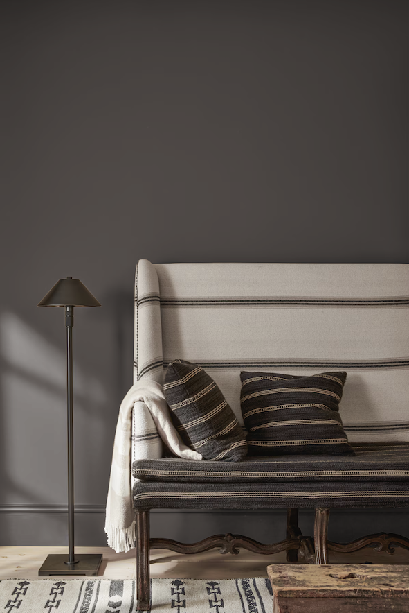 dark wall with couch, table, and lamp