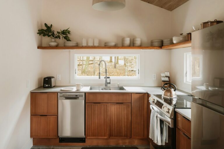 kitchen with wood cabinets and wood shelf with bowls and cups. There is a window and decor.