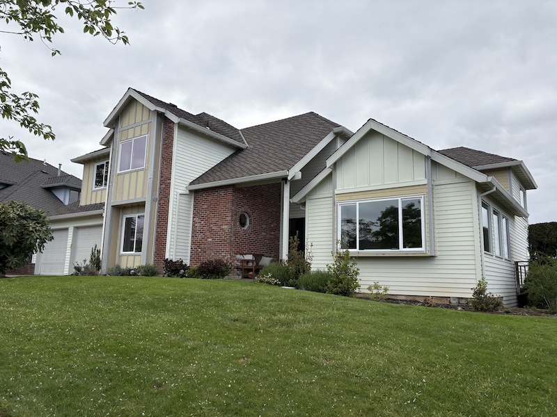 wide angle shot of creamy yellow house with Northwest Contemporary style architecture with brick, windows, and angles.