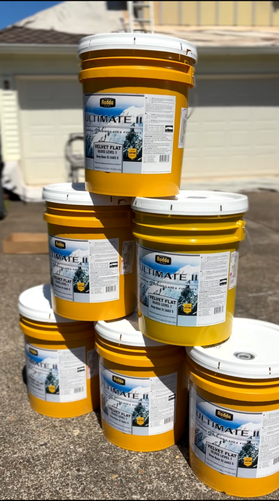 buckets of rodda miller paint sitting on a driveway