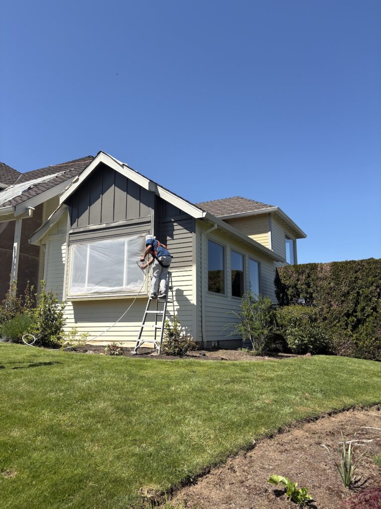 cream colored house being painted dark gray